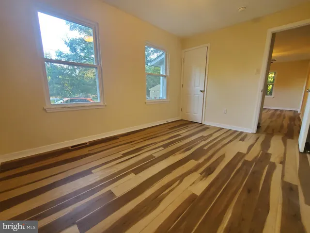 a view of a room with wooden floor and window