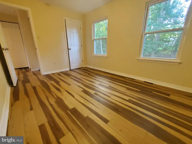 a view of a room with wooden floor and windows