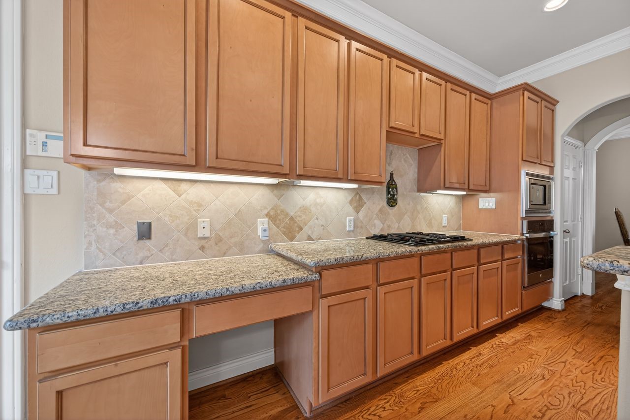 10932 Lasso Lane Houston, TX 77079 - Photo 11 of 38 a kitchen with granite countertop stainless steel appliances a sink stove and cabinets
