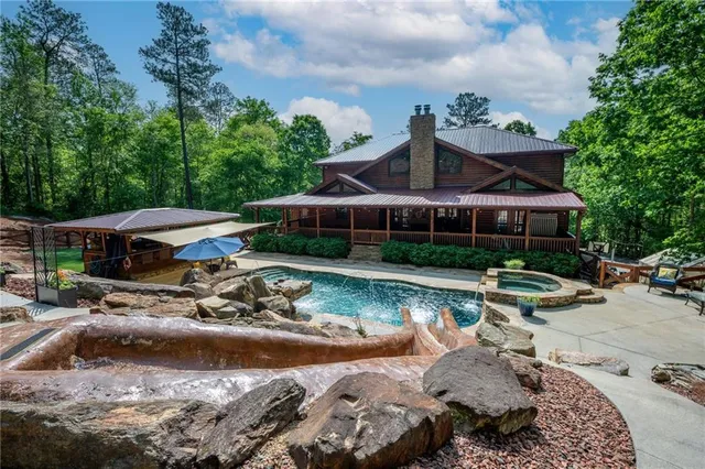 a view of a house with swimming pool and furniture