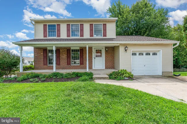 a view of a brick house with a yard and plants