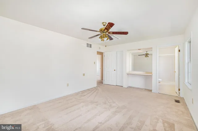 a view of a room with a ceiling fan and a window