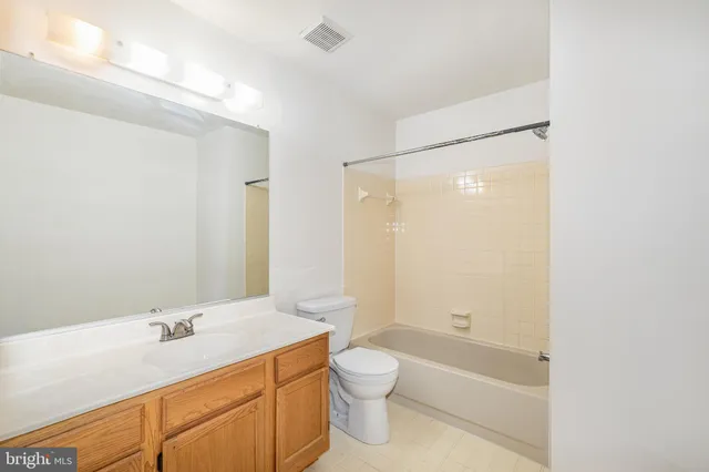 a bathroom with a granite countertop sink a toilet and shower