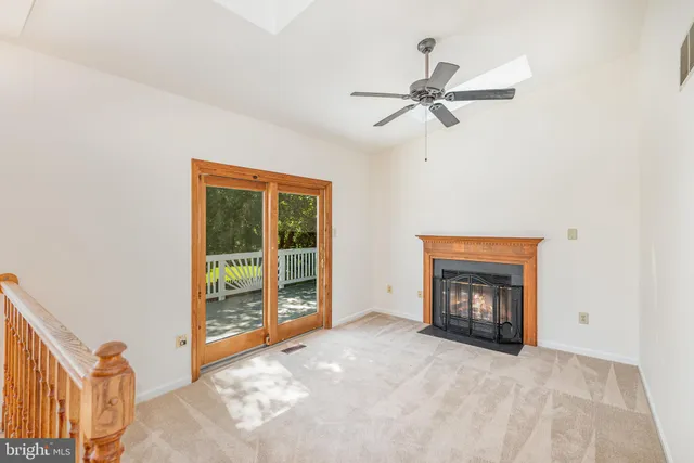 a view of an empty room with a fireplace and a window