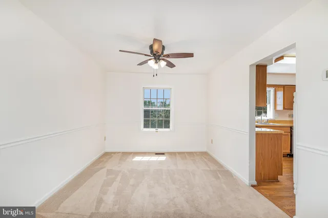 an empty room with a window and a ceiling fan