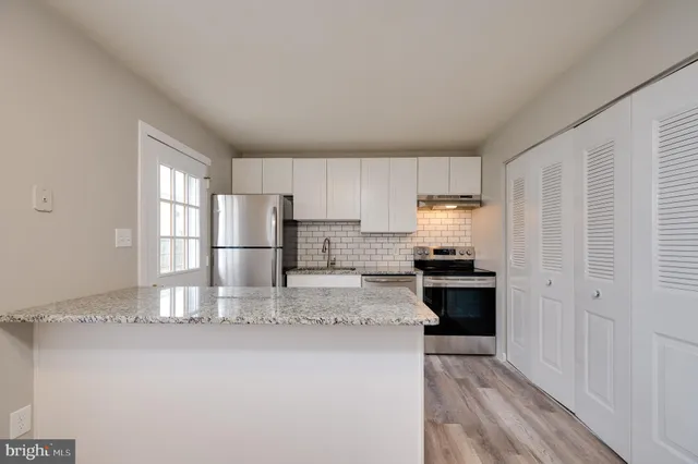 a kitchen with stainless steel appliances granite countertop a refrigerator sink and stove