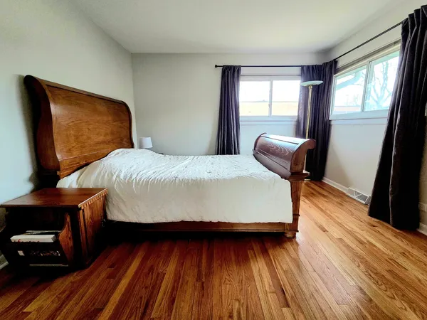 a bedroom with a bed and wooden floor
