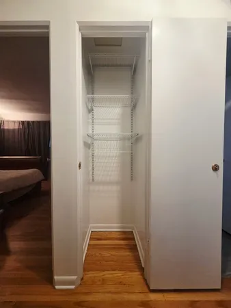 a view of a hallway with wooden floor and closet