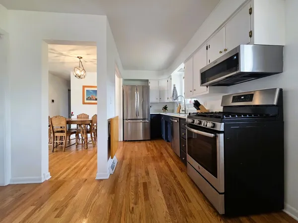 a kitchen with stainless steel appliances a stove a sink a microwave and cabinets
