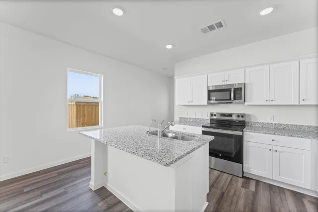 a kitchen with stainless steel appliances granite countertop a sink stove microwave and cabinets