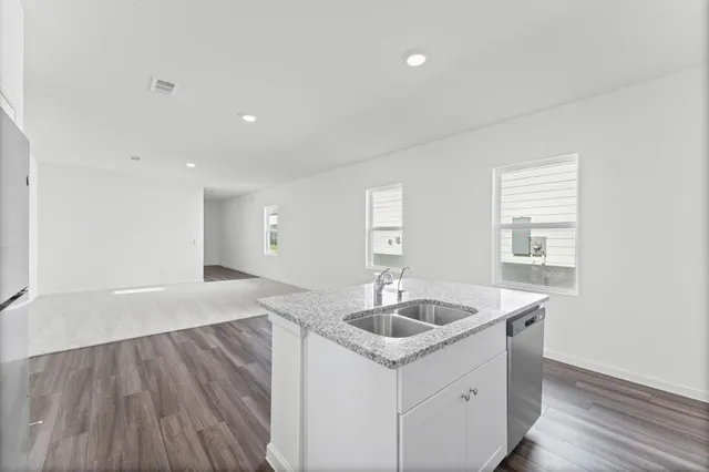 a kitchen with a sink cabinets and wooden floor