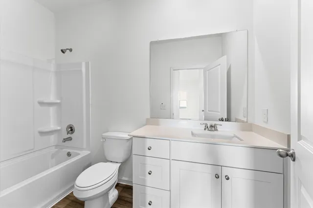a bathroom with a sink toilet vanity and tub