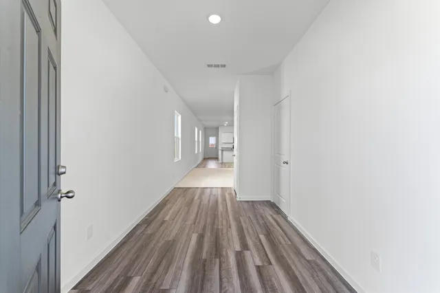 a view of a hallway with wooden floor