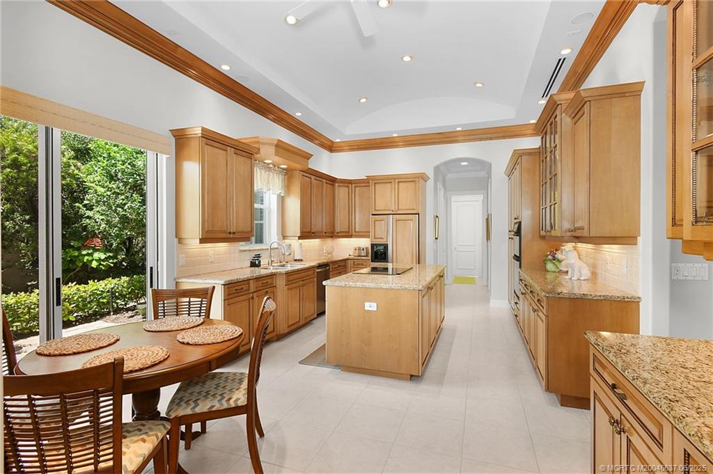 1572 Southeast Cypress Glen Way Stuart, FL 34997 - Photo 12 of 49 a large kitchen with kitchen island a large window in it