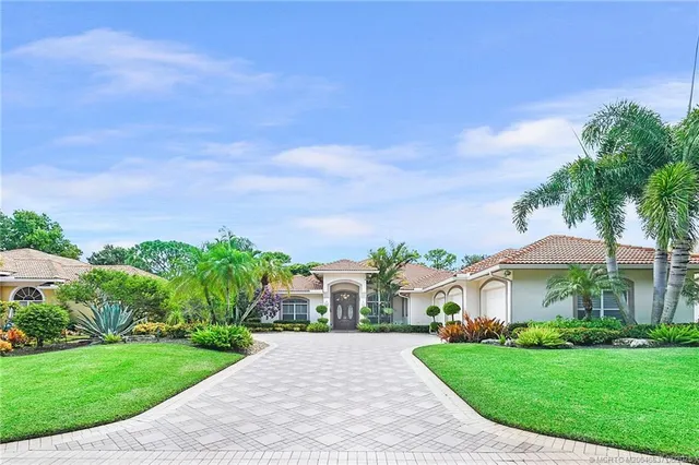 a front view of a house with a yard and trees