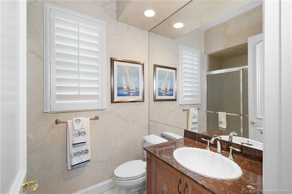 1572 Southeast Cypress Glen Way Stuart, FL 34997 - Photo 22 of 49 a bathroom with a toilet a sink a mirror a window and vanity