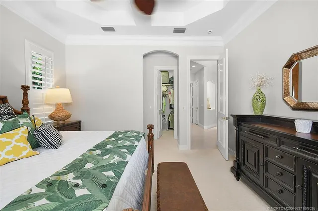 a bedroom with a bed and a lamp on dresser