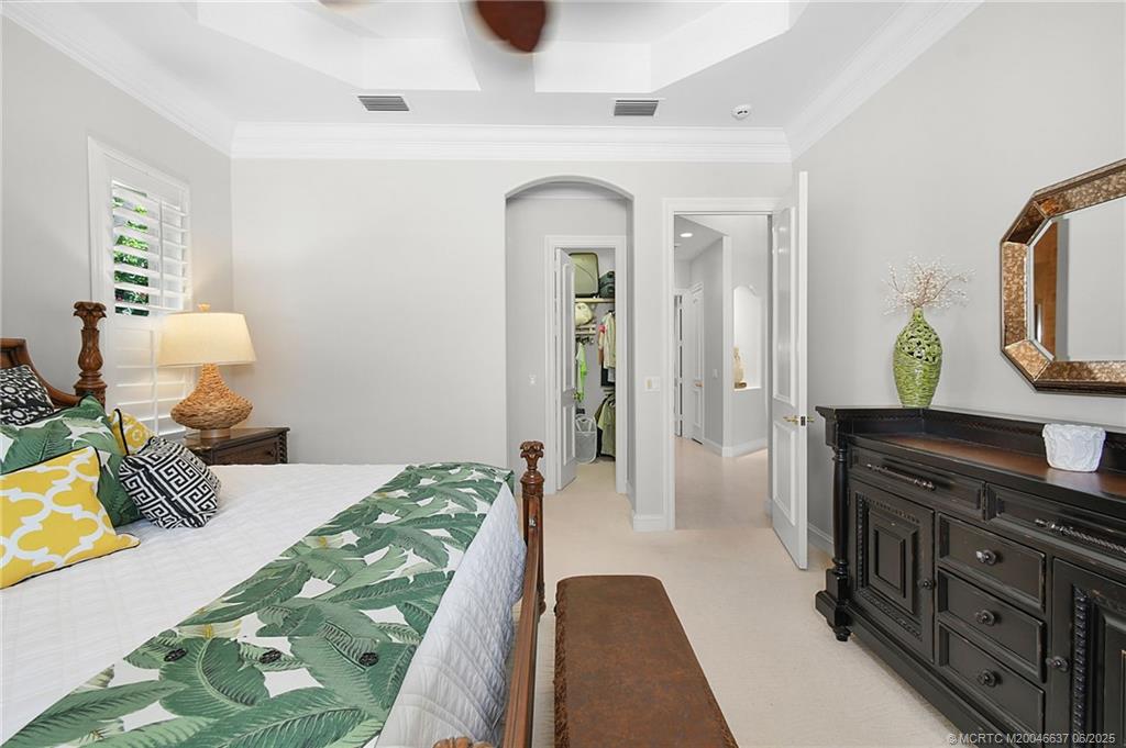 1572 Southeast Cypress Glen Way Stuart, FL 34997 - Photo 24 of 49 a bedroom with a bed and a lamp on dresser