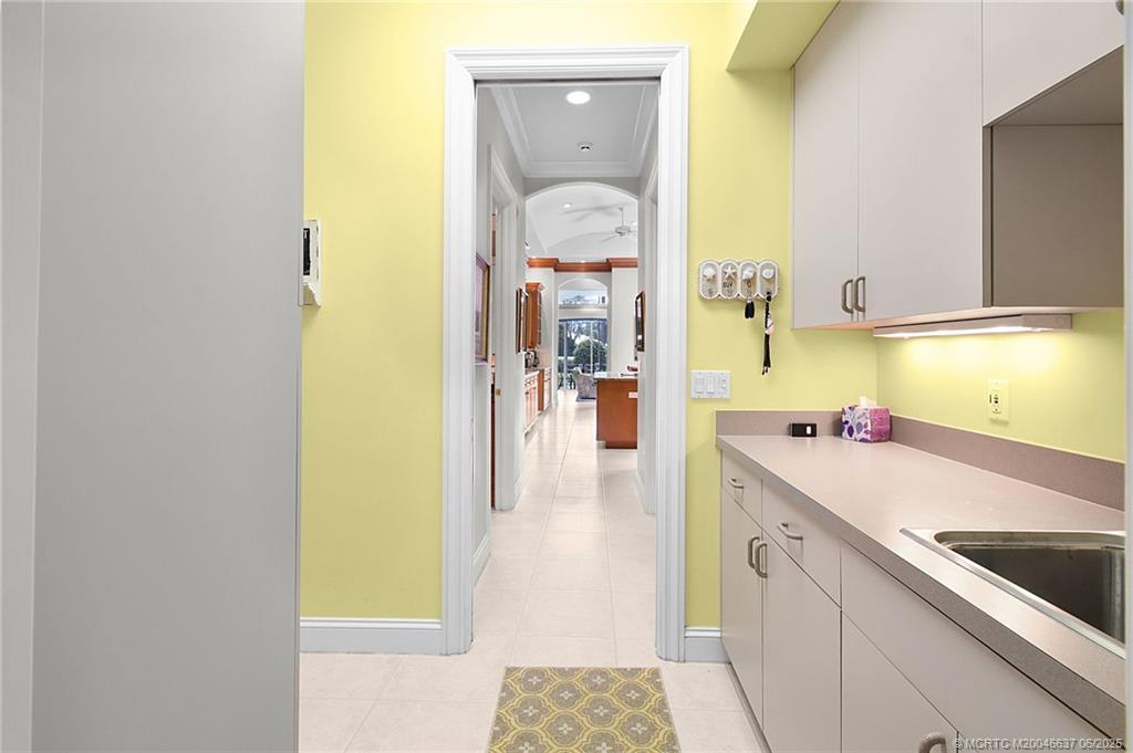 1572 Southeast Cypress Glen Way Stuart, FL 34997 - Photo 25 of 49 a kitchen with a sink and a refrigerator