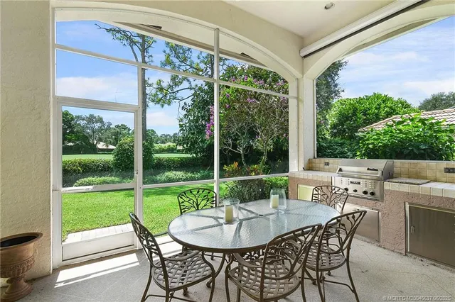 a view of a patio with a big yard table and chairs