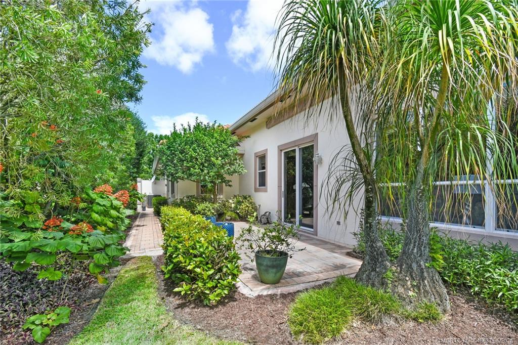 1572 Southeast Cypress Glen Way Stuart, FL 34997 - Photo 30 of 49 a front view of a house with a garden