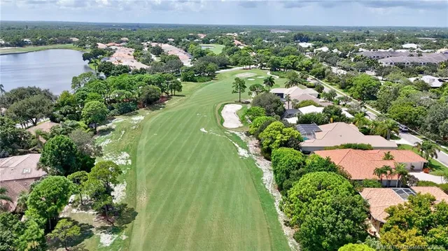 an aerial view of a residential houses with outdoor space and trees
