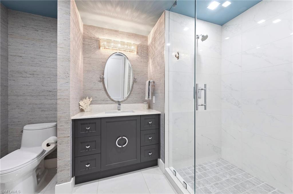 13915 Old Coast Road, Unit 1706 Naples, FL 34110 - Photo 28 of 49 a bathroom with a sink mirror vanity and toilet