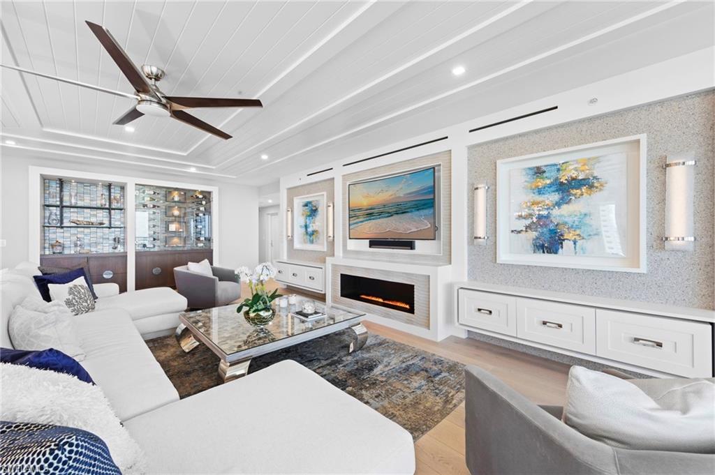 13915 Old Coast Road, Unit 1706 Naples, FL 34110 - Photo 7 of 49 a living room with furniture a flat screen tv and a fireplace