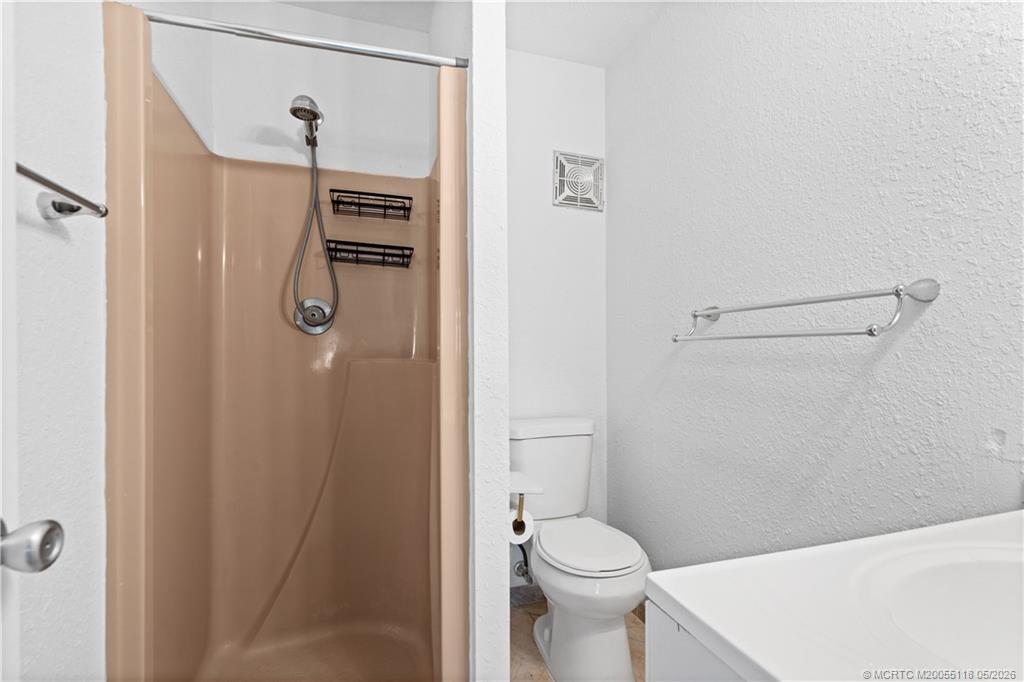 2118 Southeast Edler Drive, Unit B Stuart, FL 34994 - Photo 16 of 20 a bathroom with a shower a toilet and sink