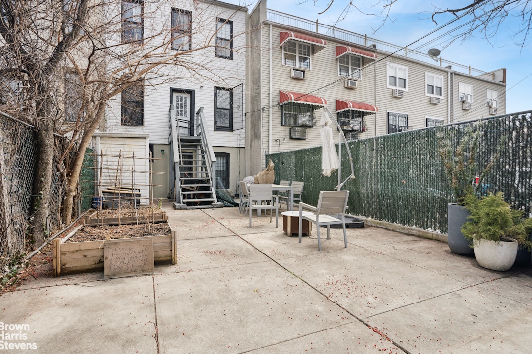 189 Cornelia Street Brooklyn, NY 11221 - Photo 6 of 8 a view of a patio with a table and chairs and potted plants