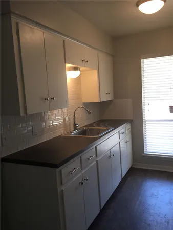 a kitchen with cabinets appliances and a window