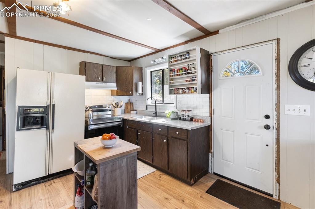 679 Calcite Drive Divide, CO 80814 - Photo 11 of 35 a kitchen with a refrigerator a sink and wooden floor