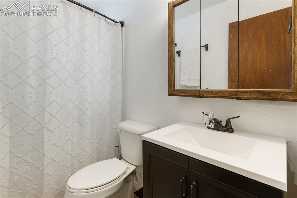 679 Calcite Drive Divide, CO 80814 - Photo 20 of 35 a bathroom with a sink a toilet and shower curtain