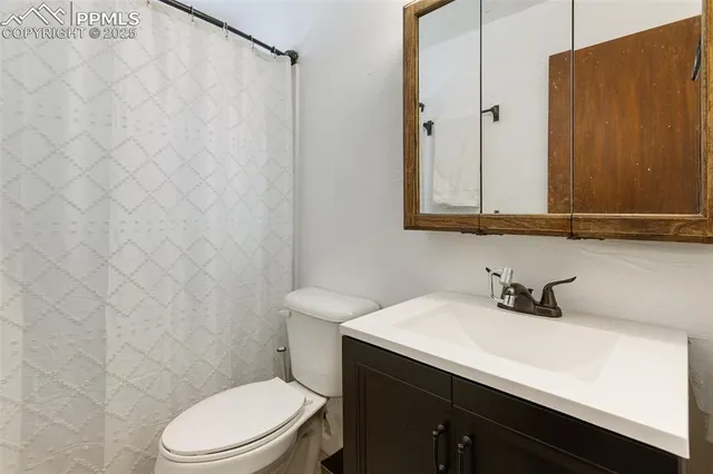 a bathroom with a sink a toilet and shower curtain