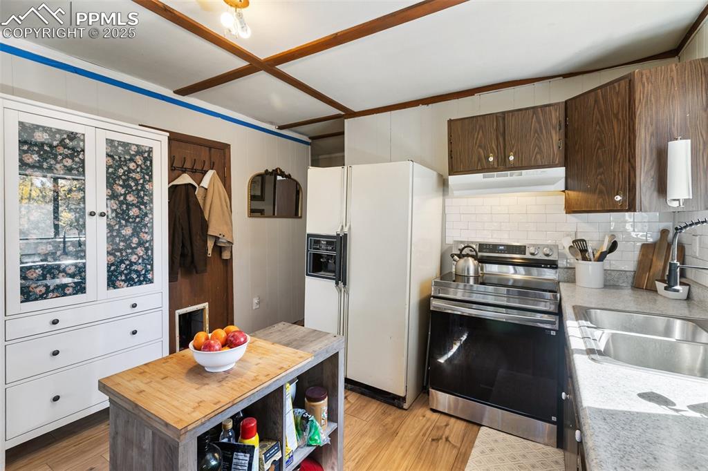 679 Calcite Drive Divide, CO 80814 - Photo 8 of 35 a kitchen with stainless steel appliances granite countertop a refrigerator a stove and a wooden floors