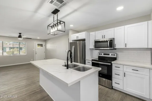 a kitchen with stainless steel appliances a sink stove and refrigerator
