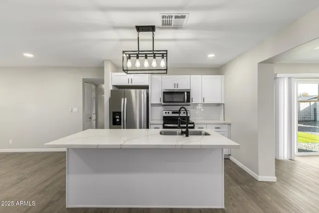 a kitchen with stainless steel appliances a refrigerator sink and microwave