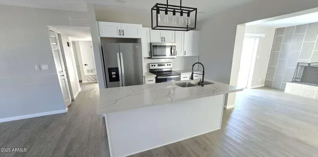 a kitchen with stainless steel appliances granite countertop a refrigerator and a sink