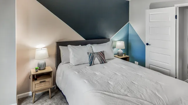 a bedroom with a bed and a painting on the wall