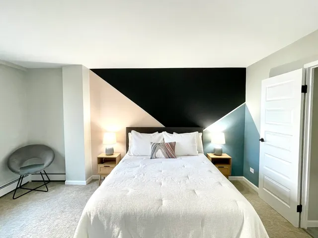 a large bedroom with a large bed and large windows