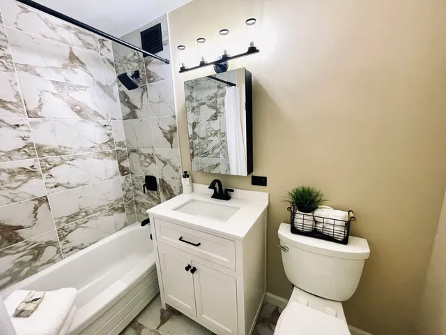 a bathroom with a bathtub sink and mirror