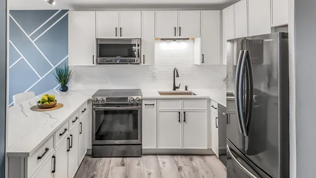 a kitchen with stainless steel appliances a stove a refrigerator and a cabinets