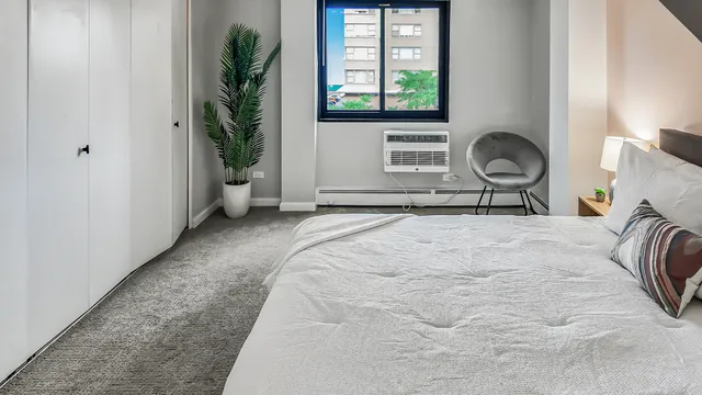 a bed room with a bed and a chair