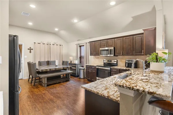 a kitchen with kitchen island granite countertop a stove and a refrigerator
