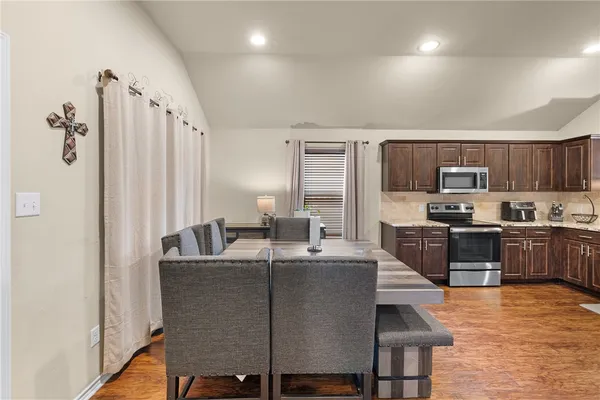 a living room with stainless steel appliances kitchen island granite countertop furniture and a refrigerator