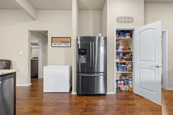 a room with wooden floor and a kitchen