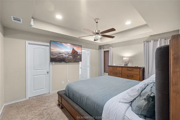 a bedroom with a large bed a chandelier and closet