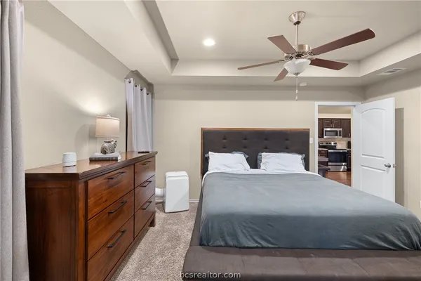 a bedroom with a large bed and a chandelier