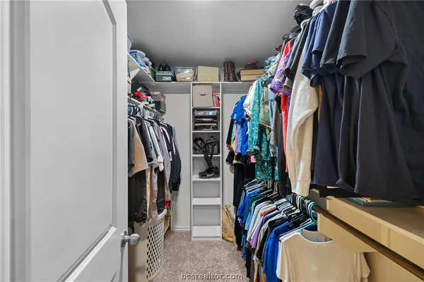 a view of walk in closet with clothes