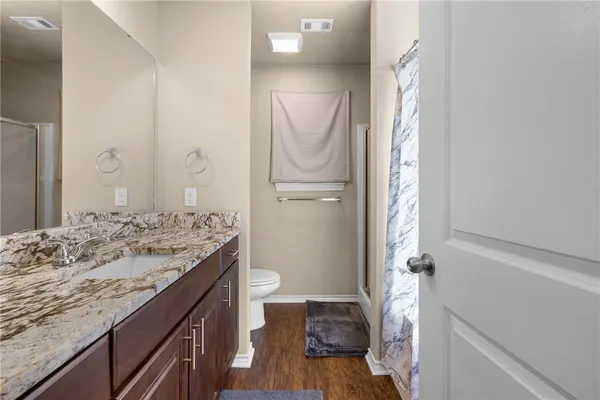 a bathroom with a granite countertop sink toilet and shower